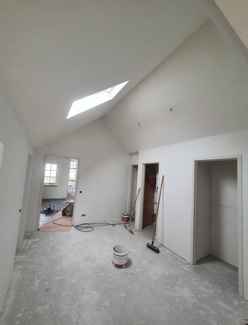 Hal met lichtstraat en strak wit stucwerk