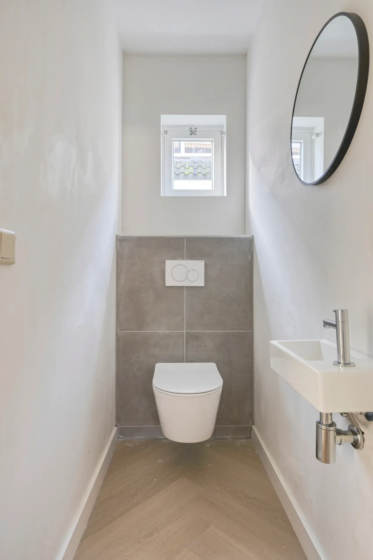 Modern toilet met strak stucwerk en betonlook tegels